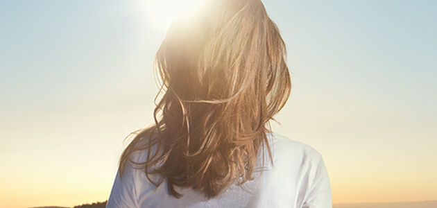 woman standing under the sun - L'Occitane