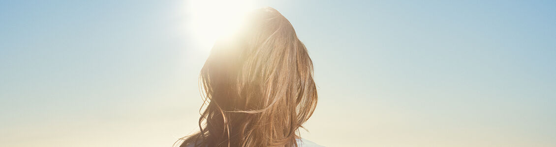 woman standing under the sun - L'Occitane